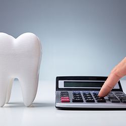 Model tooth and calculator representing cost of cosmetic dentistry in Wylie